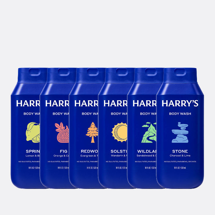 Row of blue Harry's Body Wash bottles with different scents on a white background