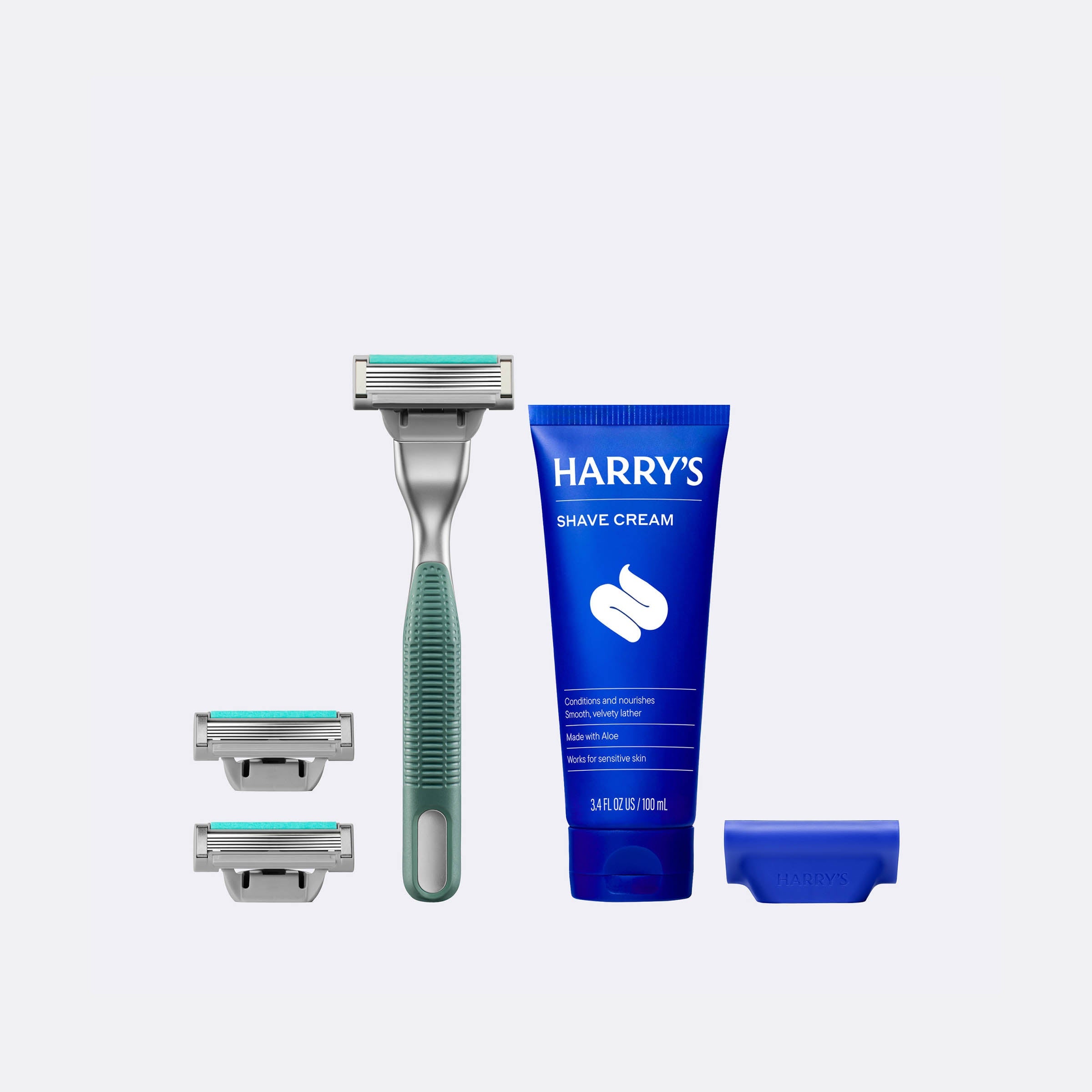 Harry's shaving kit with a razor, three razor heads, and a tube of shave cream on a white background