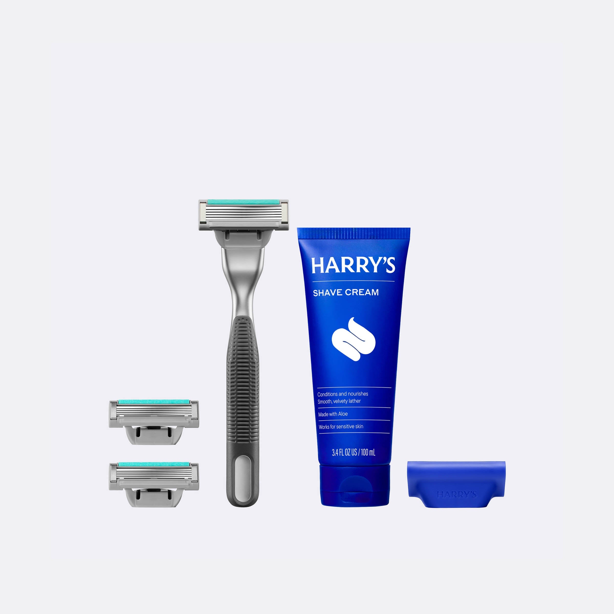 Harry's shaving kit with razor, razor heads, and shave cream on a white background